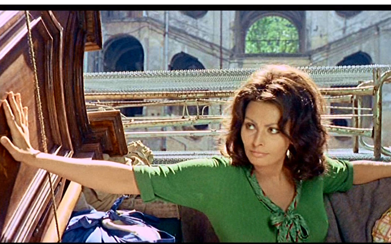 In fotografia si vede l'attrice Sofia Loren, protagonista della pellicola Questi fantasmi, e sullo sfondo l'antico Palazzo Sanfelice, sito in via Sanità