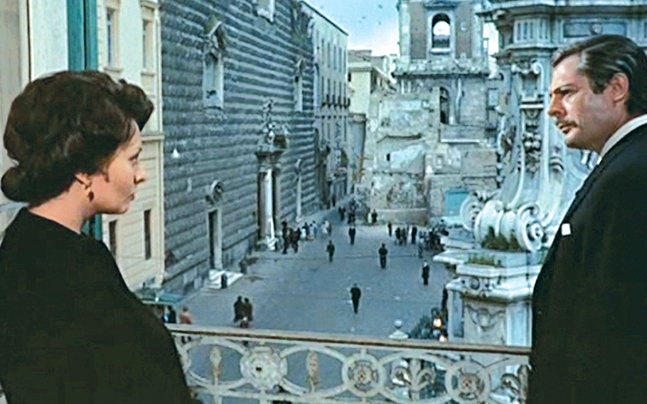 Sofia Loren e Marcello Mastroianni in una scena tratta dal film Matrimonio all'italiana girata a Palazzo Pandola. Sullo sfondo si vede Piazza del Gesù Nuovo