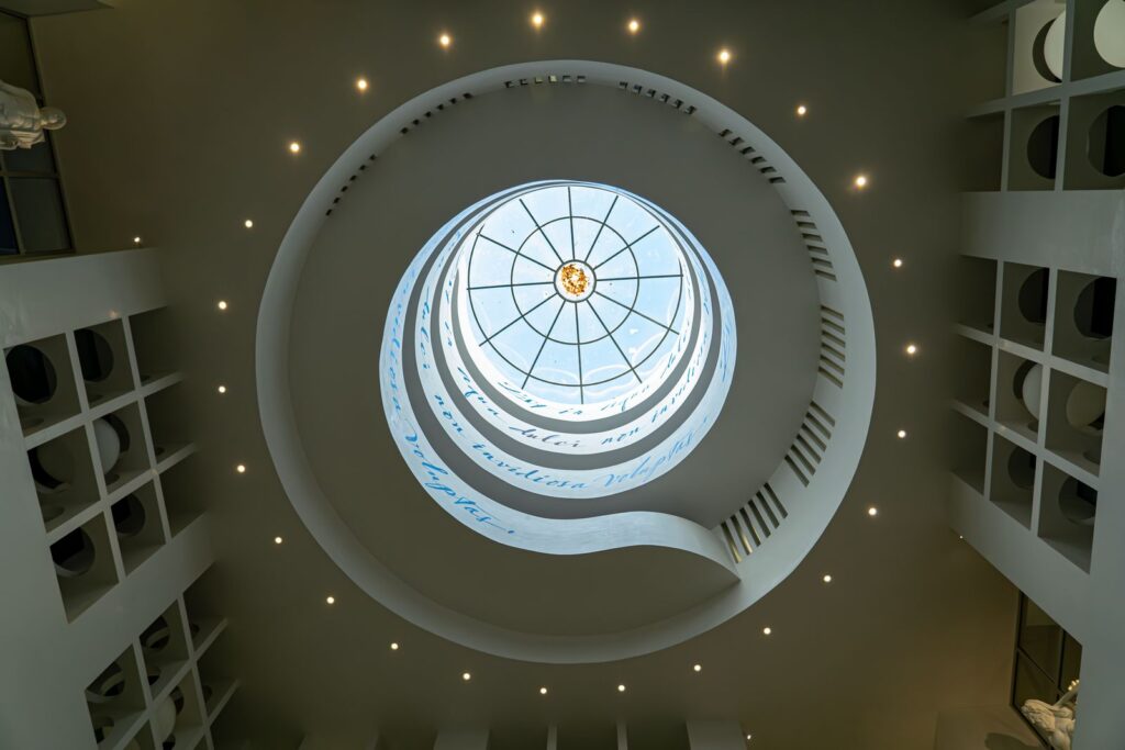 Cupola bianca con rampa a spirale dedicata a Nettuno nella stazione Chiaia – Monte di Dio, simbolo del viaggio negli abissi.