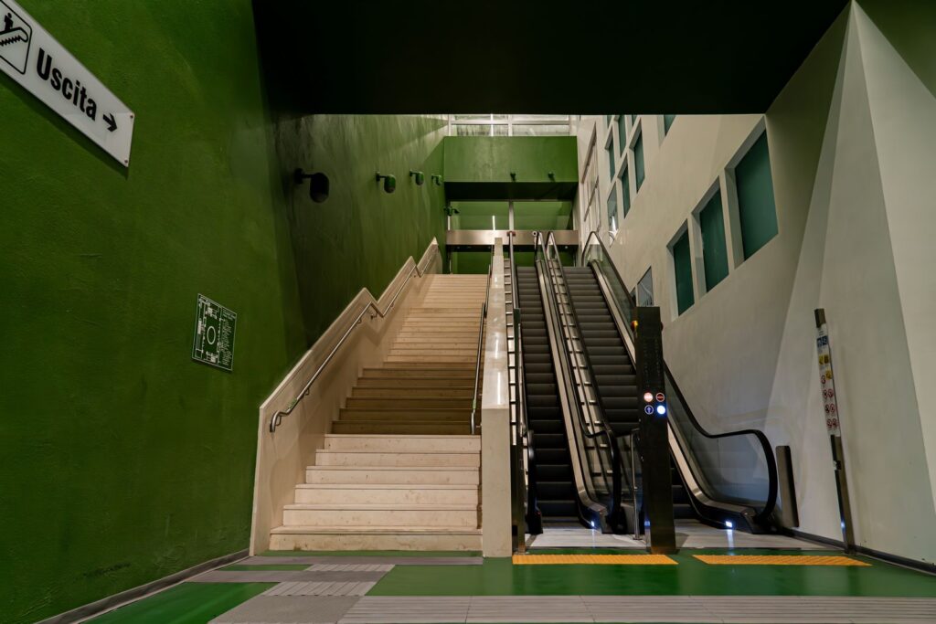 Scale e scale mobili dell’area verde di Cerere nella stazione Chiaia – Monte di Dio, simbolo della risalita verso la luce.