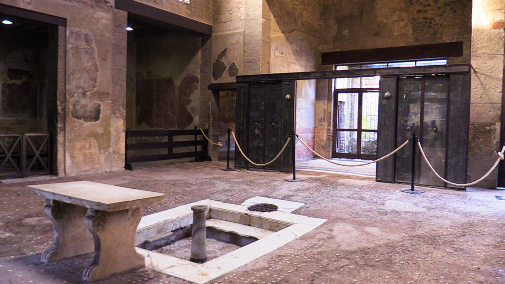 Interno della Casa del Tramezzo di Legno a Herculaneum, con strutture lignee conservate che mostrano la vita domestica nell’antica Roma