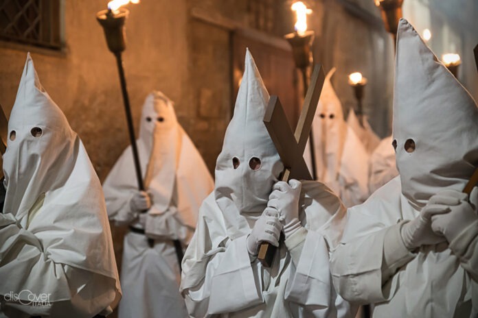 Confratelli vestiti di bianco con il volto coperto durante la Processione Bianca di Sorrento in onore della Madonna Addolorata