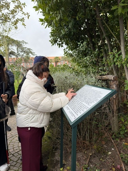 L'accessibilità al Museo e Real Bosco di Capodimonte: un viaggio sensoriale nel Giardino dei Principi 3 Una giovane visitatrice legge un pannello in Braille immerso nel verde del Real Bosco di Capodimonte, parte del nuovo percorso di accessibilità.